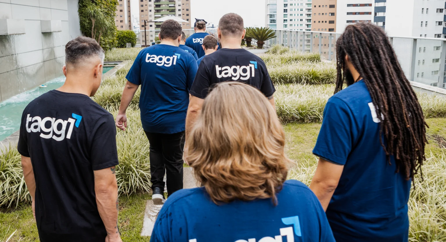 Integrantes da equipe com camisetas da Tagg One em uma área externa