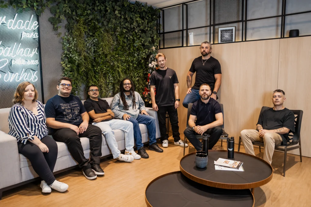 Equipe da Tagg One reunida no espaço de convivência do escritório